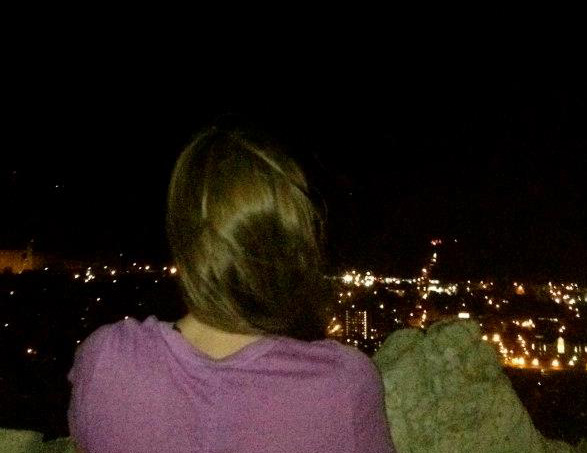 A girl looking out over Winona from Garvin Heights at night