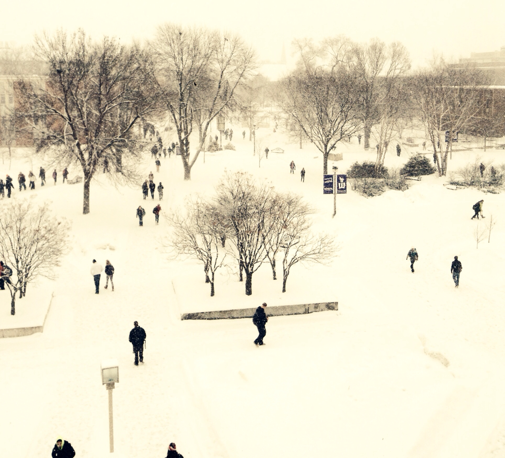 students walk across the snow covered campus