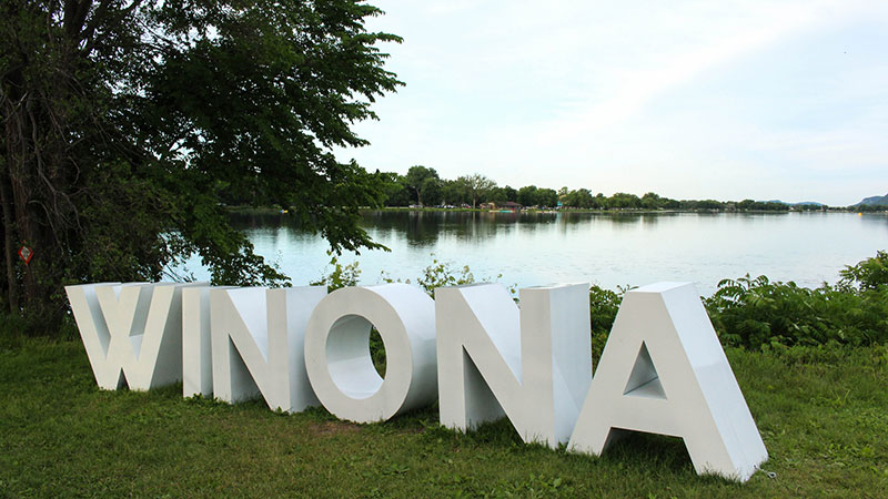A large sign says "Winona" in front of the big lake