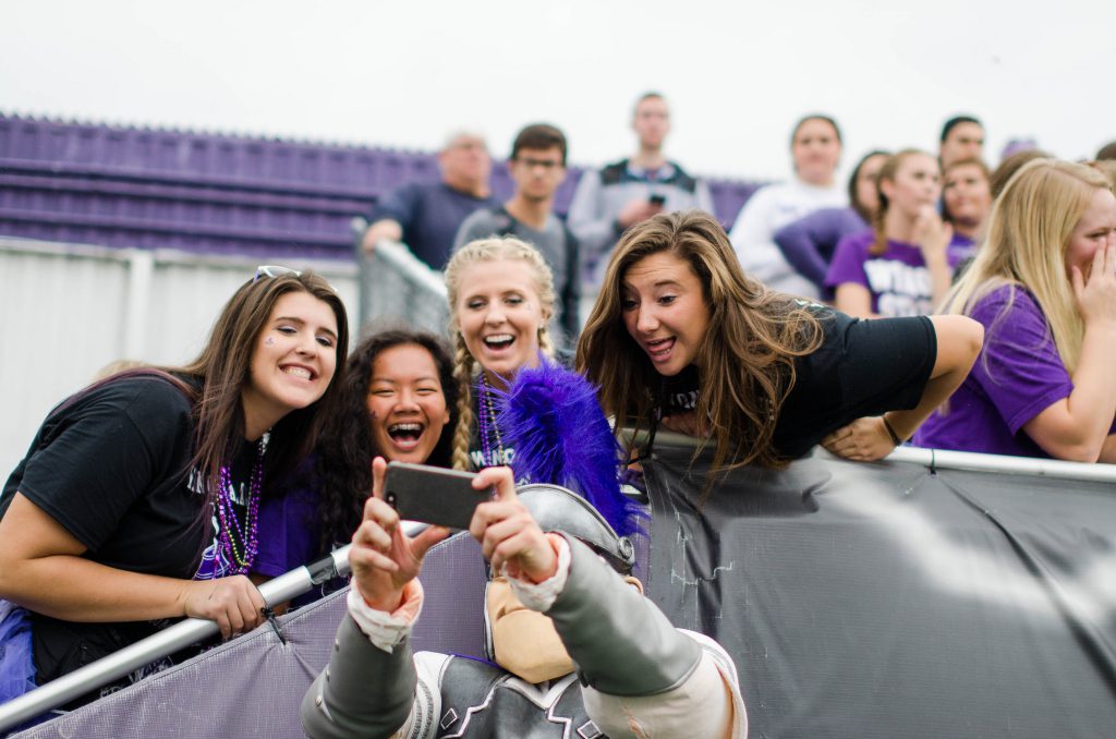 Students in the football student section taking a selfie with Wazoo.