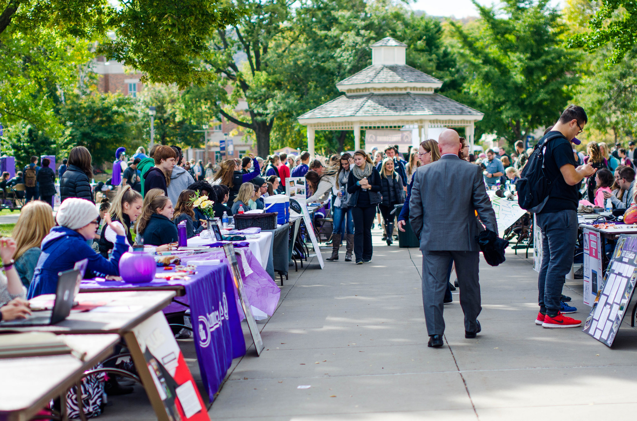 Students perusing around a club fair in the courtyard on campus.
