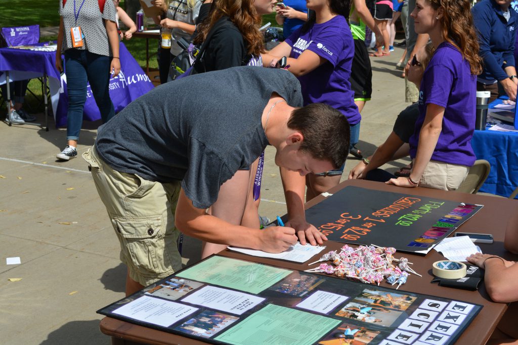 WSU student signing up for a club at the club fair on campus.