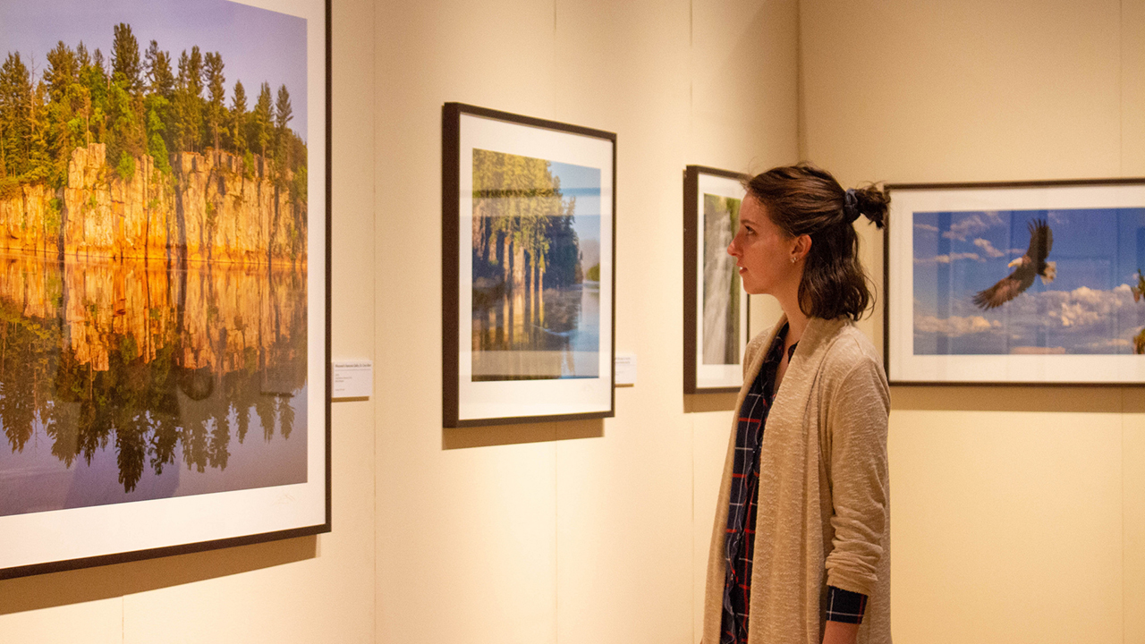 Student admires a photograph displayed at MMAM.