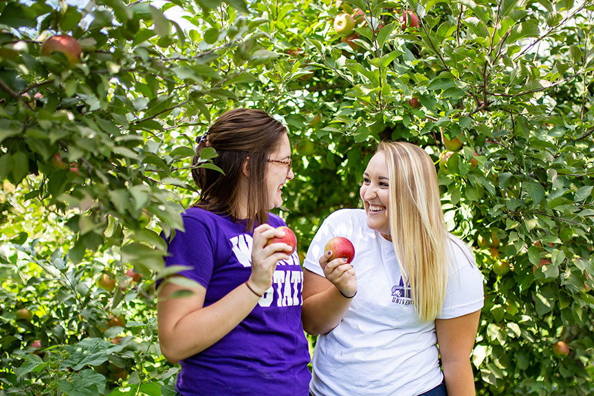 Two girls at the apple orchard.