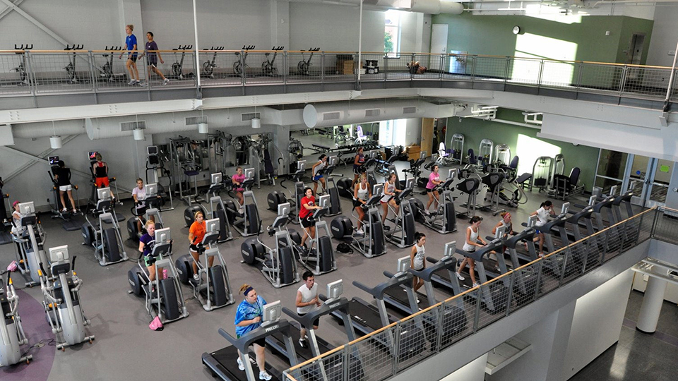 Studens use cardio equipment on the second floor of the IWC and walk on the indoor track.
