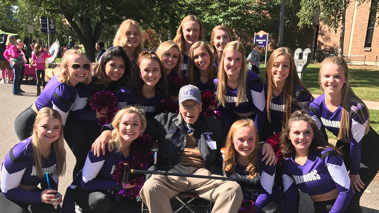 Mo Weber smiles surrounded by cheerleaders at WSU Homecoming.