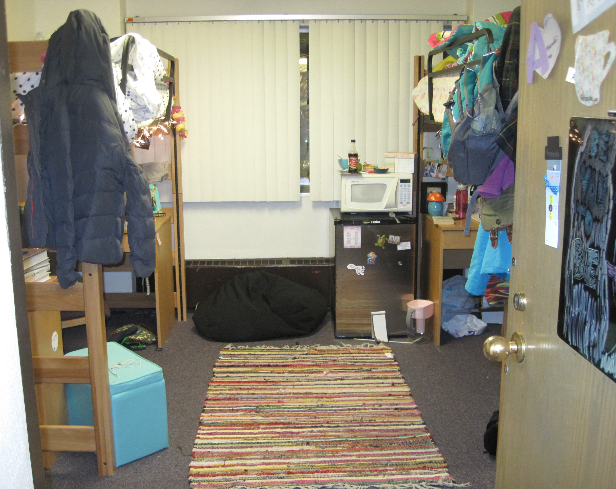 A dorm room with two lofted beds