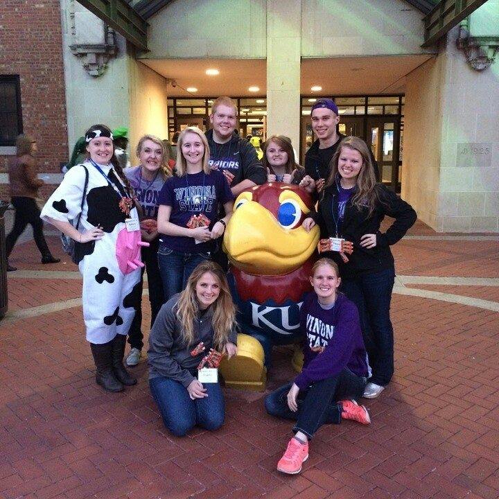 WSU students posing in front of the Kansas University mascot, the jayhawk.