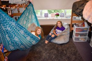 Roommates hanging out in hammocks in room