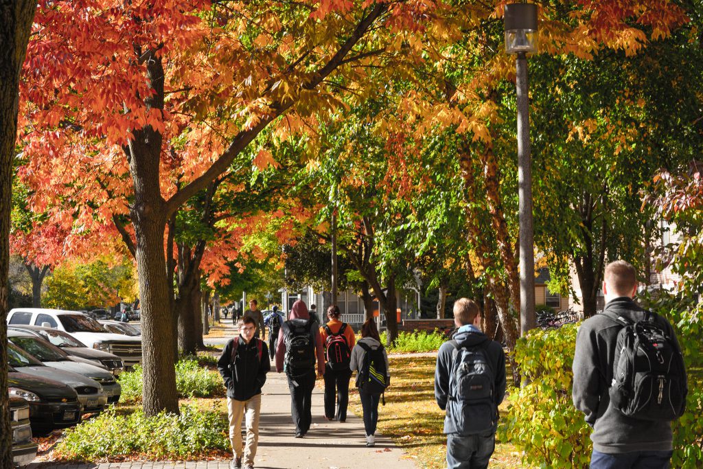 Students walking across campus on a fall day.