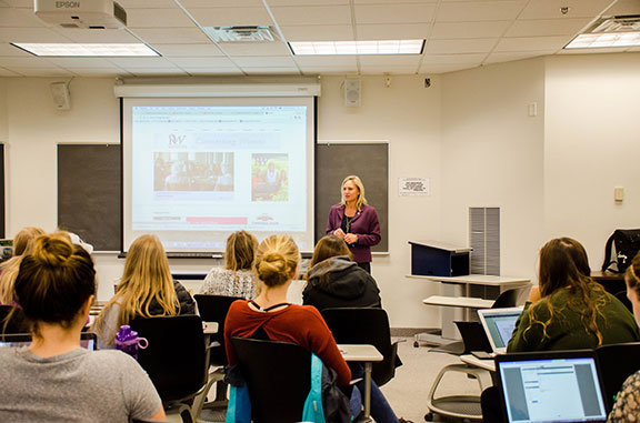 A guest speaker speaking in front of a class of WSU students.