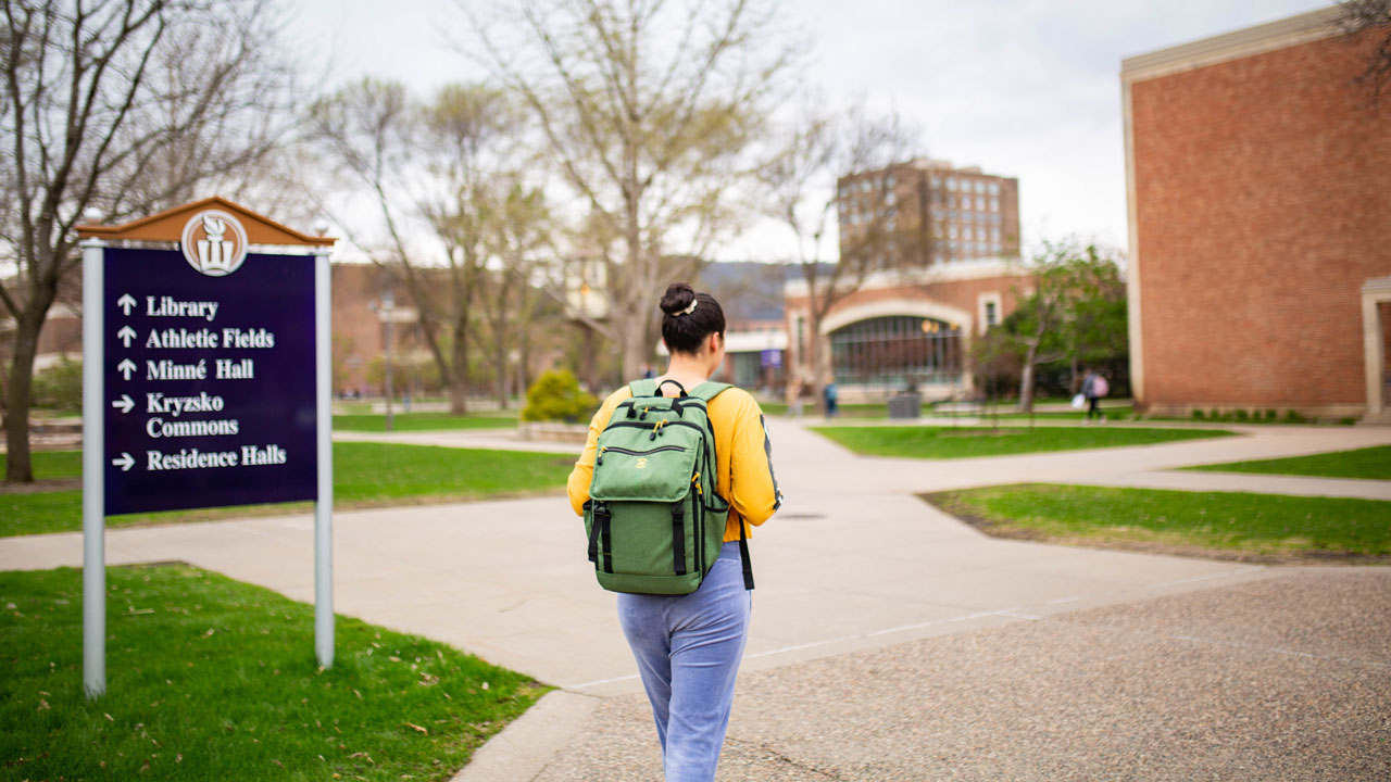 Girl walking through campus with backpack