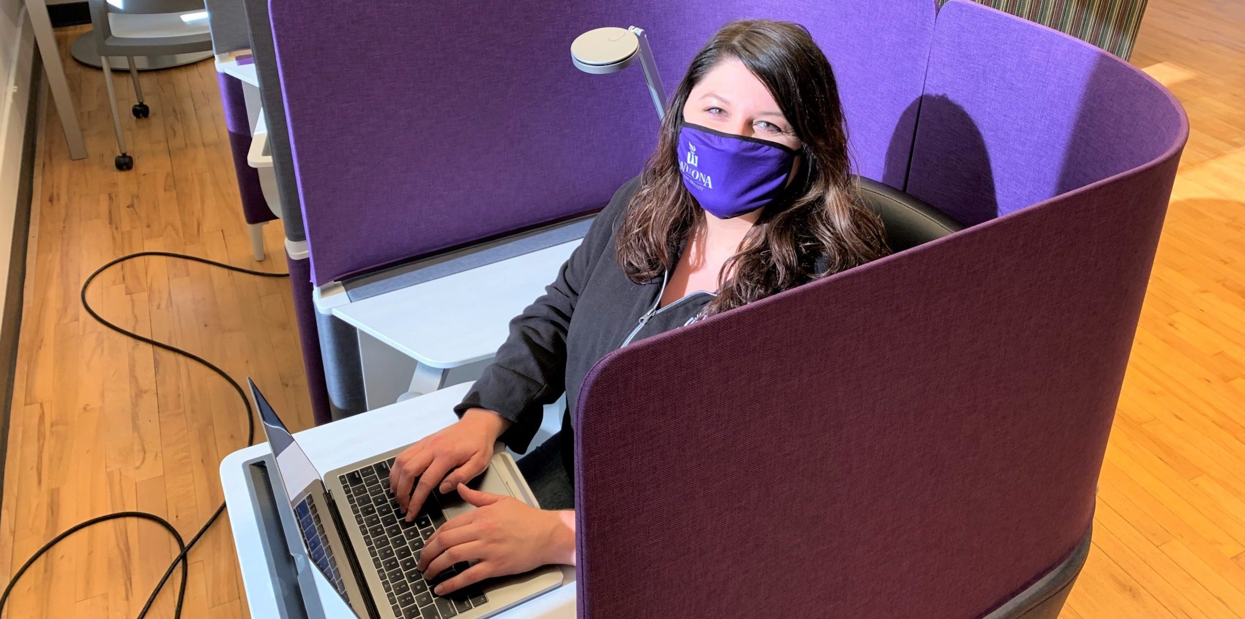 A WSU student studies in the WSU-Rochester on Broadway campus building while wearing a mask and socially distancing.