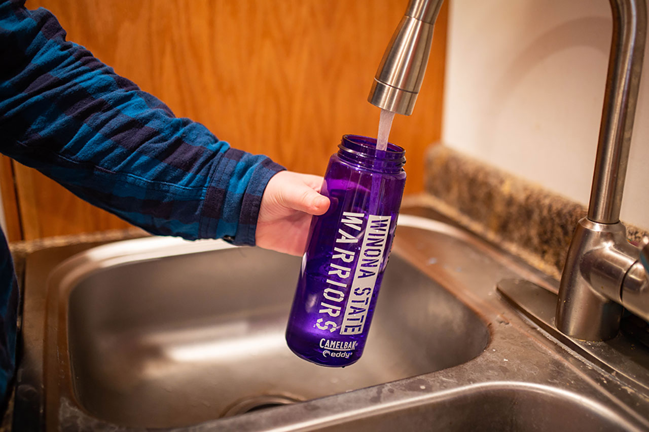 student filling up reusable water bottle