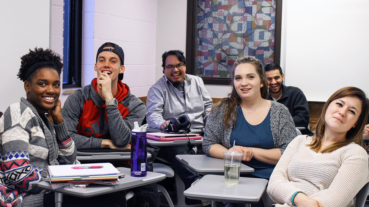 A group of WSU students sit together in desks during class.